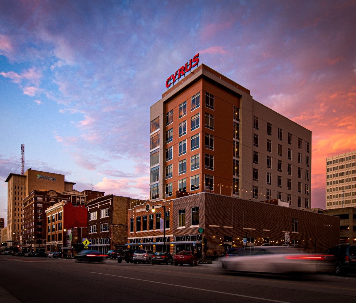 A view of a street in downtown Topeka, Kansas. The tallest building has a sign that says "Cyrus".